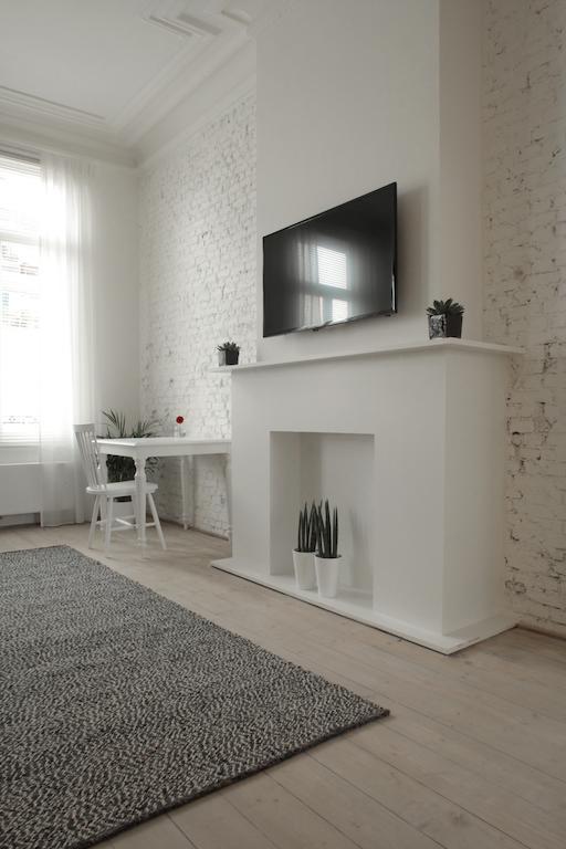 Maison Nationale City Flats & Suites Anversa Camera foto A fireplace with a TV above it