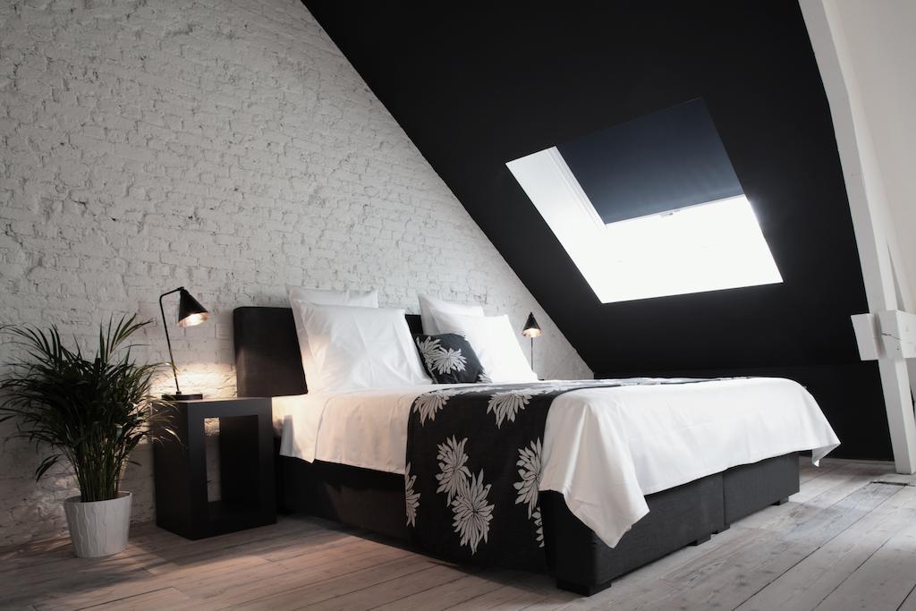 Maison Nationale City Flats & Suites Anversa Camera foto A bedroom with a roof window